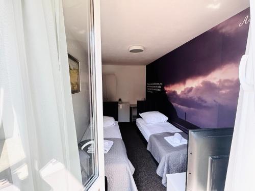 a hotel room with two beds and a mirror at Sztorm Rowy in Rowy