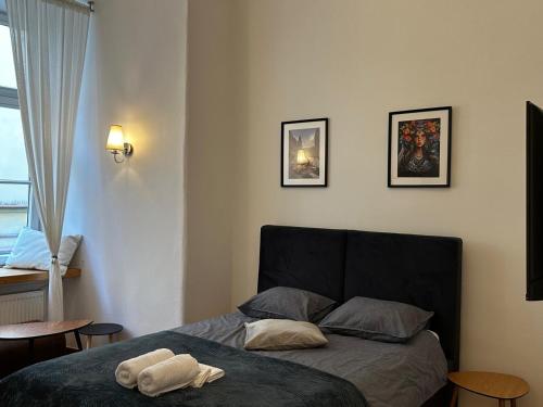 a bedroom with a bed and three pictures on the wall at Rynek 5 Stara Winiarnia in Lublin