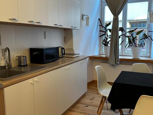 a kitchen with a microwave and a table with chairs at Rynek 5 Stara Winiarnia in Lublin