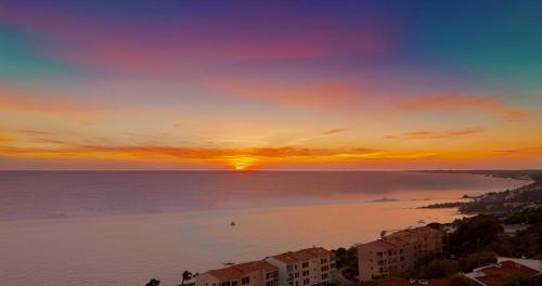 un coucher de soleil sur l'océan avec le soleil dans le ciel dans l'établissement VUE MER EXCEPTIONNELLE !! Studio calme et lumineux sur la prestigieuse route des Sanguinaires à Ajaccio, à Ajaccio