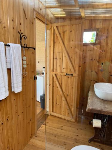 a bathroom with a wooden wall with a sliding barn door at למדבר- חווית גלמפינג במדבר in Arad