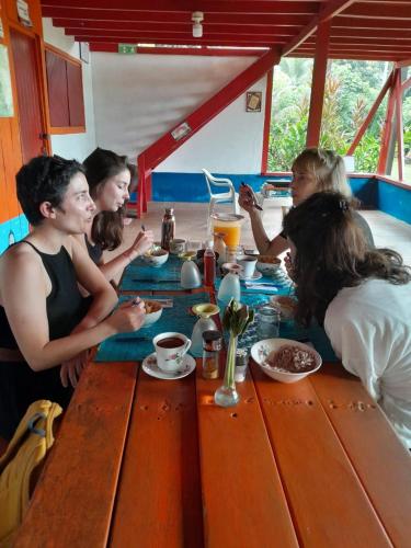 a group of people sitting around a table eating at Cabaña El Bien Germina Ya in El Valle