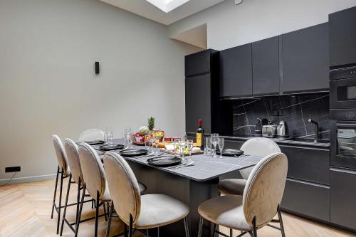 une salle à manger avec une table et des chaises dans une cuisine dans l'établissement Elegant apartment with AC - 3BR-10P- Le Marais, à Paris
