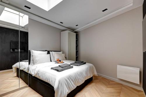 une chambre avec un grand lit avec des draps blancs dans l'établissement Elegant apartment with AC - 3BR-10P- Le Marais, à Paris