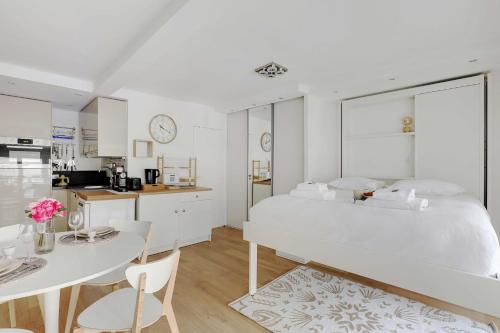 une chambre blanche avec un grand lit et une table dans l'établissement Cozy studio - 2P - Place de la Bourse, à Paris