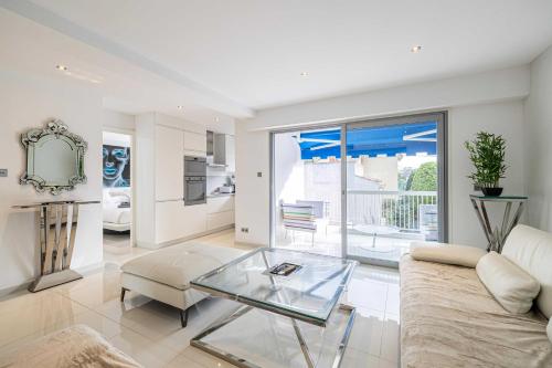 un salon avec un canapé et une table en verre dans l'établissement Beautiful apartment with sunny terrace, à Cannes