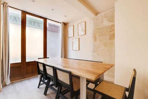 une salle à manger avec une table et des chaises en bois dans l'établissement Amazing Duplex - 5BR-12P - Montorgueil, à Paris