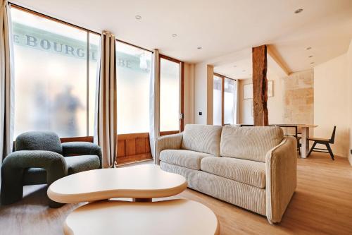 un salon avec un canapé, une table et des chaises dans l'établissement Amazing Duplex - 5BR-12P - Montorgueil, à Paris