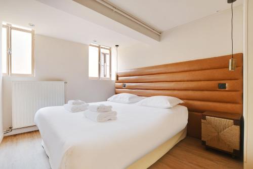une chambre avec un grand lit blanc avec des serviettes dessus dans l'établissement Amazing Duplex - 5BR-12P - Montorgueil, à Paris