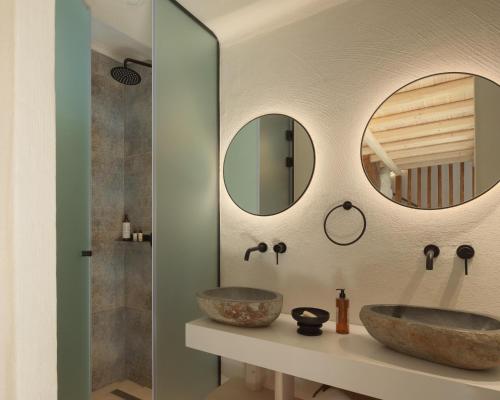 a bathroom with two sinks and two mirrors at Manili Boutique Suites & Villas in Archanes