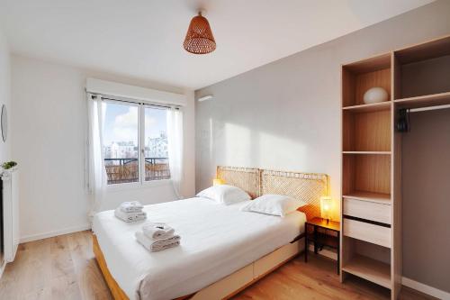 une chambre avec un grand lit blanc avec une fenêtre dans l'établissement Sumptuous 3BR-6P Apartment with terrace-Near Paris, à Saint-Ouen