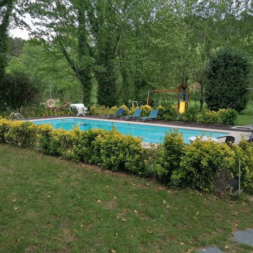 a swimming pool in a yard with chairs and flowers at Agroturismo Quinta De Travancela in Amarante