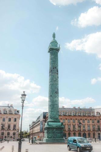 une voiture garée à côté d'un monument devant un bâtiment dans l'établissement Cozy studio - 2P - Place de la Bastille, à Paris