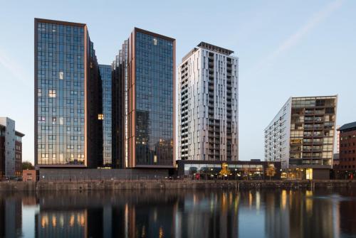 a city skyline with tall buildings and a body of water at Duet Manchester in Manchester
