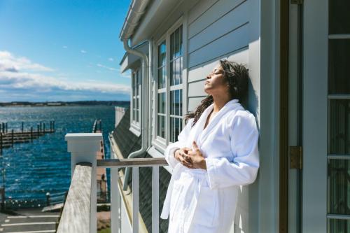 a woman standing on a balcony looking out at the water at Gardiner House in Newport