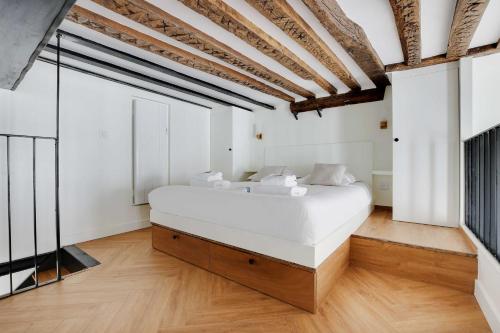 une chambre avec un grand lit blanc dans une pièce dans l'établissement Charming Apartment - 1BR-5P - Sentier, à Paris
