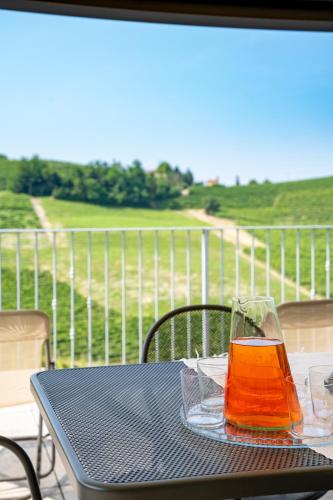 a glass of juice sitting on a table on a balcony at Casa Pajè in Barbaresco