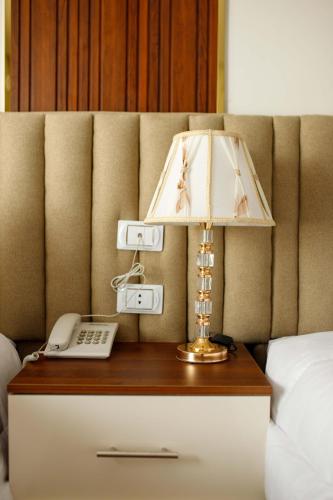 a lamp on a table with a phone on a bed at Pyramids Sunshine View in Cairo