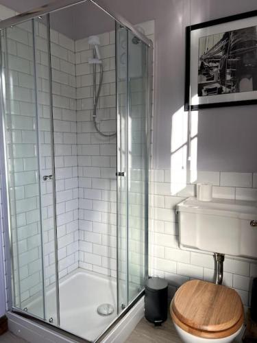 a bathroom with a shower with a toilet and a sink at Jubilee View, Studio Apartment in Matlock Bath in Matlock Bank