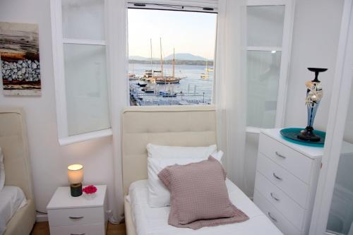 a bedroom with a bed and a window with a boat at Aroura Maisonette Spetses 4BR in Spetses