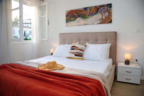 a bedroom with a bed and a painting on the wall at Aroura Maisonette Spetses 4BR in Spetses