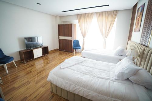 a hotel room with two beds and a television at Pyramids Sunshine View in Cairo
