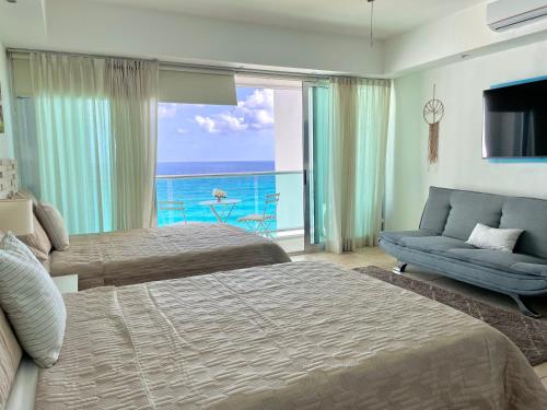 a bedroom with two beds and a view of the ocean at Beachfront Apartment by Andiani Travel in Cancún