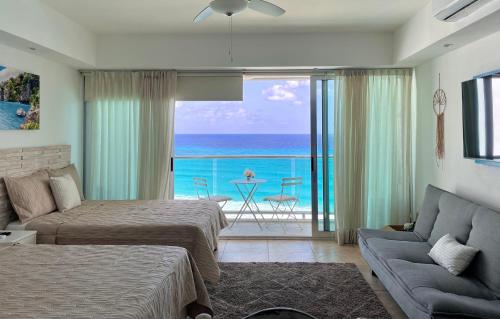 a bedroom with two beds and a view of the ocean at Beachfront Apartment by Andiani Travel in Cancún