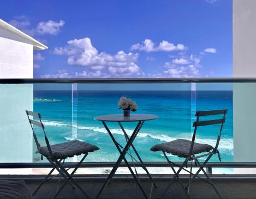 a table and two chairs in front of a window at Beachfront Apartment by Andiani Travel in Cancún