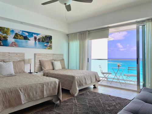 a bedroom with two beds and a view of the ocean at Beachfront Apartment by Andiani Travel in Cancún