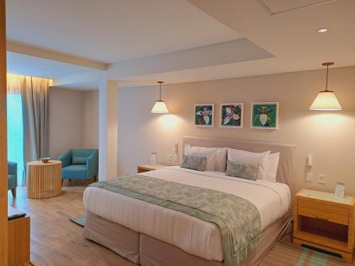 a bedroom with a large bed and a blue chair at Iguazu Jungle Lodge in Puerto Iguazú