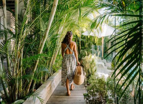 a woman walking down a wooden walkway through a garden at Finns at Old Bar in Old Bar