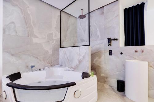 une salle de bain avec un lavabo blanc et une douche dans l'établissement Lovely Bedroom with Jacuzzi 2P Chatelet, à Paris