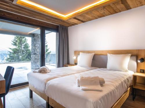 une chambre avec un grand lit et une grande fenêtre dans l'établissement Appartement 8 pers. 3 ch. avec terrasse à Montvalezan - FR-1-275-212, à La Rosière