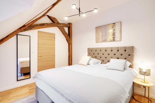 une chambre avec un grand lit blanc et un miroir dans l'établissement Charming apartment - 1BR-4P - Bastille, à Paris