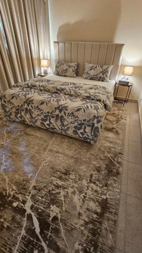 Un dormitorio con una cama grande y dos lámparas sobre mesas. en Splendid Private Rooms, en Sharjah