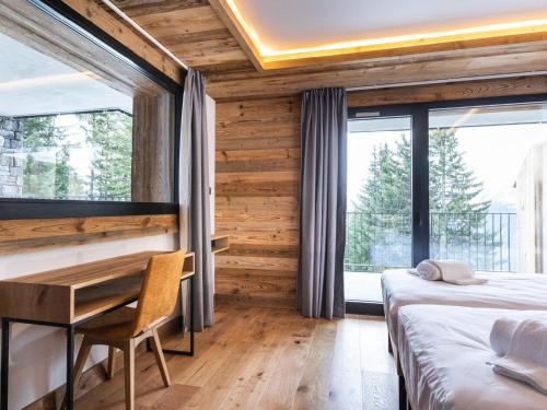 une chambre avec deux lits et un bureau et une fenêtre dans l'établissement Duplex 4 pièces familial avec terrasse - FR-1-275-215, à La Rosière