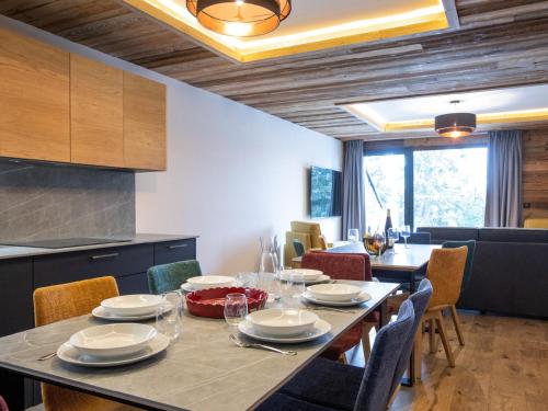 une salle à manger avec une table et des chaises et une cuisine dans l'établissement Appartement élégant 10 personnes avec terrasse et vue sur vallée - FR-1-275-216, à La Rosière