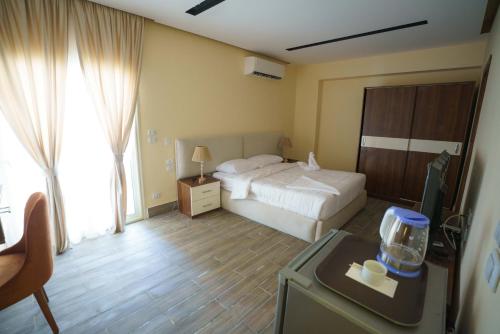a hotel room with a bed and a desk with a window at Pyramids Sunshine View in Cairo