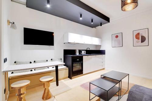 - une cuisine aux murs blancs avec une table et des chaises dans l'établissement Chic apartment - 1BR-4P - Trocadero, à Paris