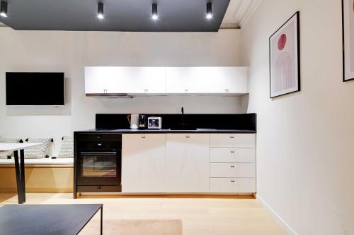 une cuisine avec des armoires blanches et un comptoir noir dans l'établissement Chic apartment - 1BR-4P - Trocadero, à Paris