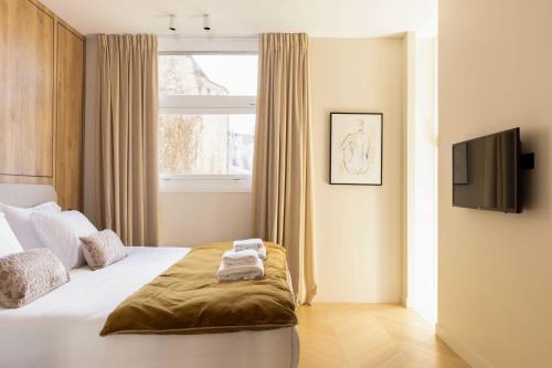 - une chambre avec un lit, une télévision et une fenêtre dans l'établissement Spacious & Modern Property - Eiffel Tower, à Paris