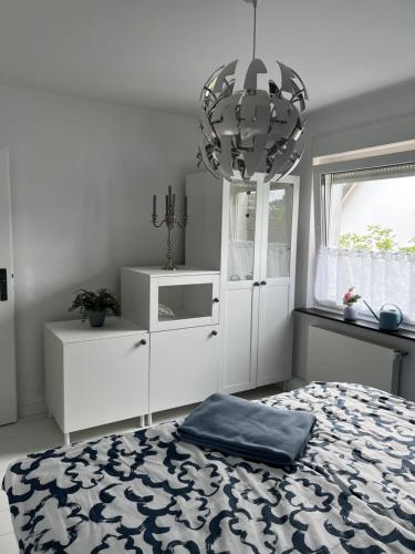 a bedroom with a bed and a chandelier at Ferienwohnung Kasia in Medebach