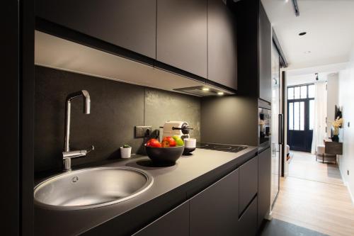 - une cuisine avec un évier et un bol de fruits sur un comptoir dans l'établissement Chic apartment - 2BR-6P - Pantheon, à Paris