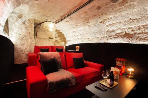 - un canapé rouge dans une chambre dotée d'un mur en pierre dans l'établissement Chic apartment - 2BR-6P - Pantheon, à Paris
