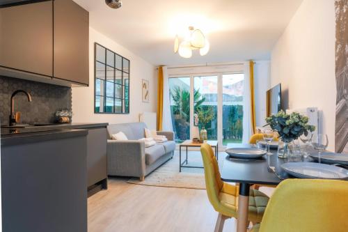 une cuisine et un salon avec une table et des chaises dans l'établissement A Cozy Nest with Garden - Montreuil - 1BR 4P, à Montreuil
