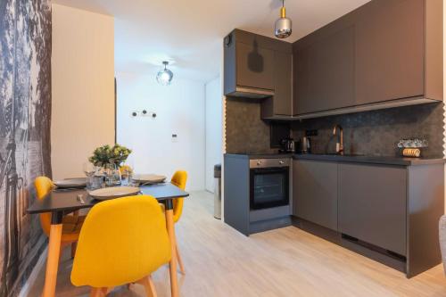 une cuisine et une salle à manger avec une table et des chaises jaunes dans l'établissement A Cozy Nest with Garden - Montreuil - 1BR 4P, à Montreuil