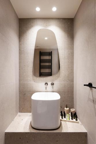 a bathroom with a white sink and a mirror at Kohili Villas - Sea View Residences in Skopelos Town