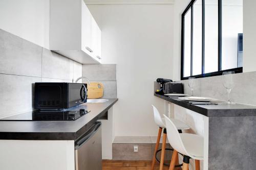 une cuisine avec un comptoir avec un micro-ondes dans l'établissement Cozy studio - 2P - Batignolles-Parc-Monceau, à Paris