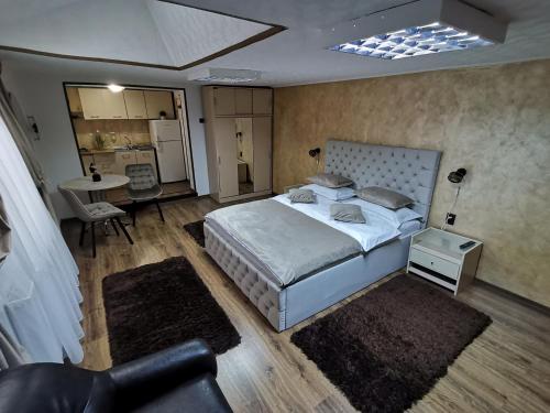 a bedroom with a large bed and a kitchen at Shelby Accommodation -Adult Only- in Sinaia